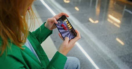 Woman playing racing on smartphone, female hands close up