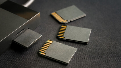 Professional photographer&rsquo;s workflow equipment. A card reader and several flash memory cards for backing up files on a dark textured background. Photo