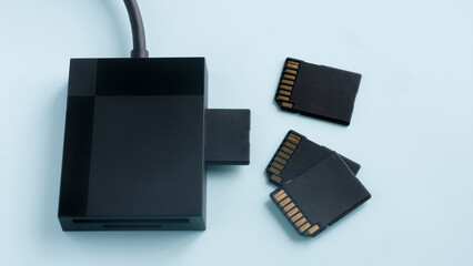 Multi-format card reader for digital memory cards. Professional photographer or content creator equipment for file backup and data transfer on a blue surface. Photo