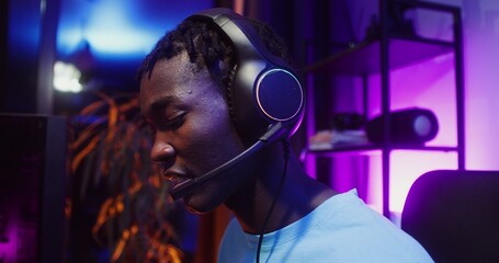 Man in headphones with a microphone playing computer video games