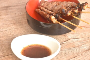 grilled salty beef meat stabbing in wooden stick on bowl dipping spicy tamarind chili sauce