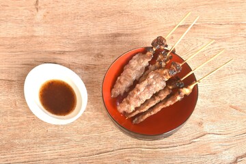 grilled salty beef meat stabbing in wooden stick on bowl dipping spicy tamarind chili sauce