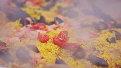Colorful seafood street food dish with mixed toppings cooked fresh on hot surface, lobster shrimp and clams on rice