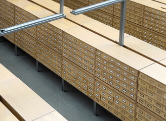 Fototapeta premium Large archive storage system with rows of wooden card catalog drawers arranged in a geometric