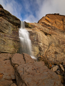 Waterfall coming over the cliff on Hastings beach from Ecclesbourne Glen east Sussex south east England UK