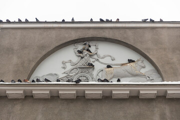 Moscow, Russia, 12 January 2026,  Architectural bas-relief on a stone wall depicting a woman in a chariot pulled by a bull with pigeons sitting on the ledge, Cinema Khudozhestvenny