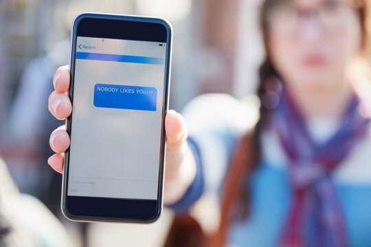 Hand, phone screen and cyber bullying at college with text message, stalker or notification at campus. Person, smartphone and rude chat with harassment, mobile app and social network at university