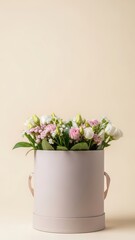 Fototapeta premium Round box with fresh pink and white flowers for gift or floral decoration. Anniversary or birthday celebration concept on beige background.