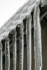 Icicles hanging from a roof on a snowy day during winter