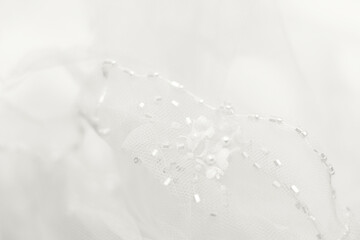Delicate cloud white dancer tulle background. Blurred wedding veil with beads. Demonstrating color, trend 2026 year.