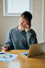Woman Suffering from Shoulder Pain While Working on Laptop in Home Office