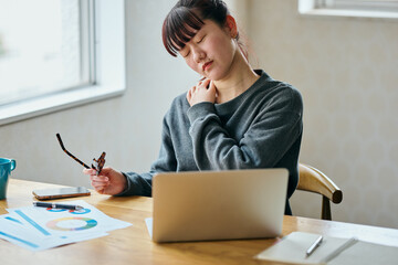 Woman Suffering from Shoulder Pain While Working on Laptop in Home Office
