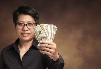 Businesswoman holding cash money with confident smile.