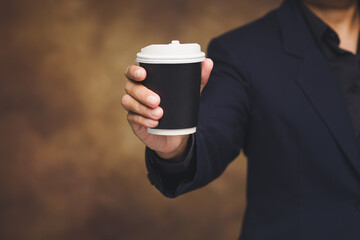 Man holding coffee cup in casual lifestyle scene.