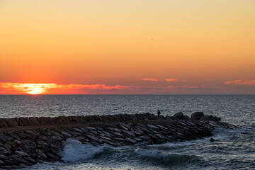 Sunset over the Atlantic Ocean with sandy beach and stone breakwater in Furadouro Portugal, Ovar &ndash; Furadouro, 11 November 2025