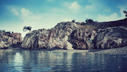 A serene rocky shoreline features calm water gently lapping against the stones. Soft clouds drift above, creating a peaceful atmosphere in nature. © icetray