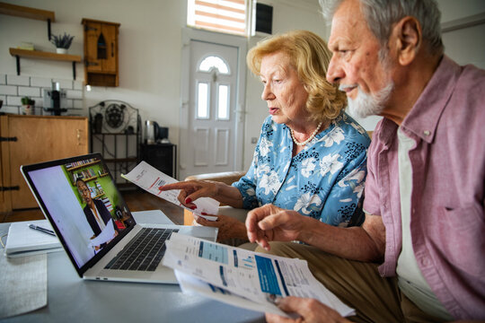 Senior couple reviewing bills during online consultation at home