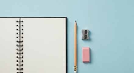 Top view of clean notebook with pencil, eraser, and sharpener on a pastel surface representing planning, writing, productivity, and academic workspace themes.