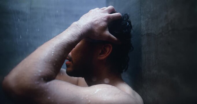 Mental health, regret and man in shower with reflection, anxiety trigger or memory of past trauma. Grief, flashback and male person in bathroom with thinking, mistake or home with emotional thoughts
