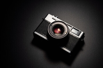 暗い背景にスポットライトが当たった古いフィルムカメラ