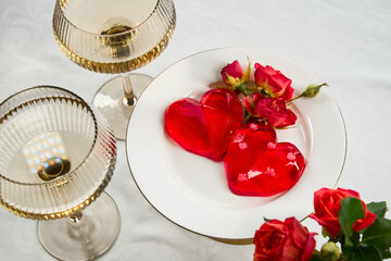 Red heart-shaped Jelly Dessert with Roses and white wine on Elegant Table Setting