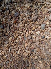 Textura de fondo de piedras pequeñas de río y grava de colores naturales en primer plano