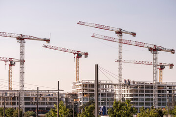 construction crane building architecture urban development property concrete scaffold montpellier France sunset glow behind tower crane over new skyline