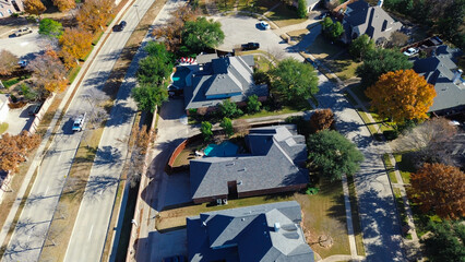 Coppell residential area with cul-de-sacs, curved roads, backyard pools, and fall-colored trees; bordered by a busy main road, showcasing suburban planning and seasonal landscaping, Texas