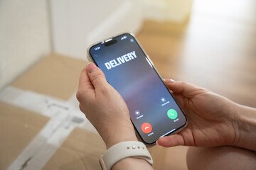 Incoming call about a parcel being delivered by courier to the front door. Last mile logistics, delivery notification and e commerce convenience. Customer experience, home delivery