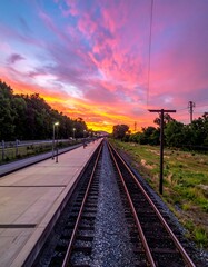 Obraz premium Railway Tracks at Sunset - A Journey into the Colorful Horizon.