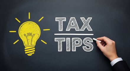 Hand writing tax tips on blackboard with lightbulb idea