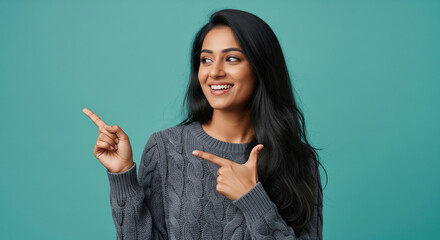 Cheerful young woman pointing with both hands to empty copy space