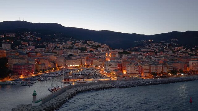 picturesque harbor during twilight hours, historic fortress overlooks tranquil water at evening. Bastia. France