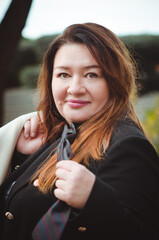Portrait of a beautiful 50-year-old woman in a business suit. Close-up, selective focus. Vertical photograph.