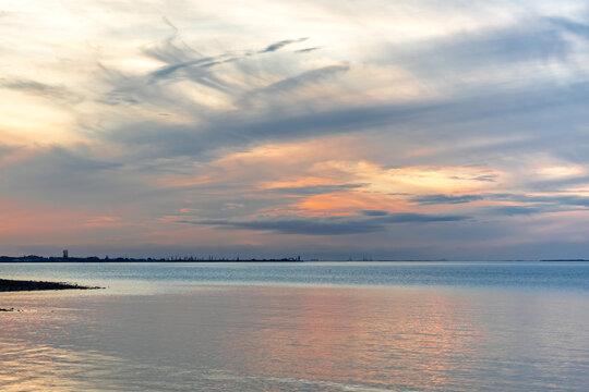 Beautiful dramatic cloudy sunset sky over the sea. View toward Cleveland Point, from Morwong Beach, Coochiemudlo Island, Queensland, Australia 