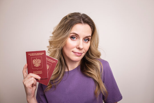 A girl with a passport on a light background is getting ready to go on vacation
