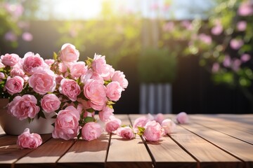 A bouquet of pink roses sits on a wooden table outdoors. Sunlight shines through the garden, creating a warm and inviting atmosphere. Pink petals scatter around
