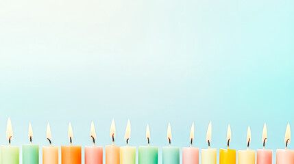 A vibrant row of lit birthday candles in various colors, creating a festive atmosphere against a soft blue background.