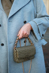 Female hand with a small bag. Concept of modern fashion, travel, city walk and personal style.