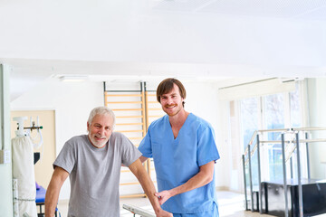 Senior Man Walking With Physiotherapist Assistance In Rehab Center For Injury Recovery And Rehabilitation Indoors Healthcare Settings