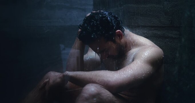 Sad, lonely and man in shower thinking for disappointment, failure and crisis. Bathroom, dark and person with depression, reflection and mistake for mental health, burnout and frustrated in home