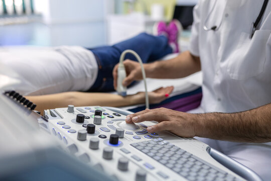 Professional Sonographer Performing Arm Ultrasound on Patient. Specialist Using Medical Imaging Equipment for Musculoskeletal Assessment. Diagnostic Procedure for Tendon and Soft Tissue Evaluation.