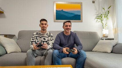 Father and son playing video games on couch