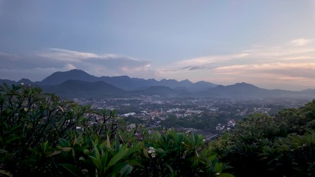 Luang Prabang cityscape view from Mount Phousi at dusk in Laos Southeast Asia. This travel destination offers a scenic landscape with mountains and sky making it a popular tourist attraction.