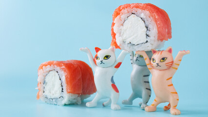 Team of miniature cat figurines holding up a delicious salmon and cream cheese roll. Humorous scene for a sushi bar menu or a food ordering service. Photo