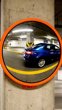 Parking lot mirror shows view of empty space and wall at indoor location during daytime