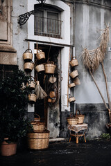 Rustic Entrance With Hanging Baskets And Straw Decor: Traditional Mediterranean House Facade Featuring Woven Containers And Natural Materials