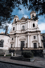 Church Of San Camillo Ai Crociferi In Catania, Sicily: Historic Baroque Church Facade With Twin Bell Towers And Stone Architecture Under Cloudy Sky