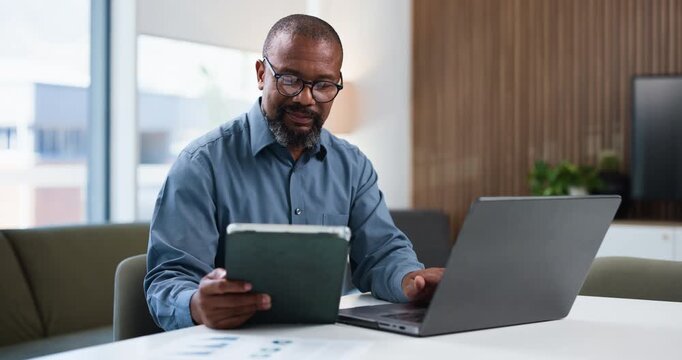Businessman, typing and tablet in office with laptop for data entry, financial planning and audit. Mature, black person and evaluation in workplace with computer, tech and stats for finance report.