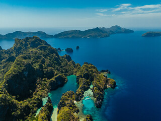 Crystal-clear turquoise water surrounded by dramatic limestone cliffs in the Big and Small Lagoons of Palawan